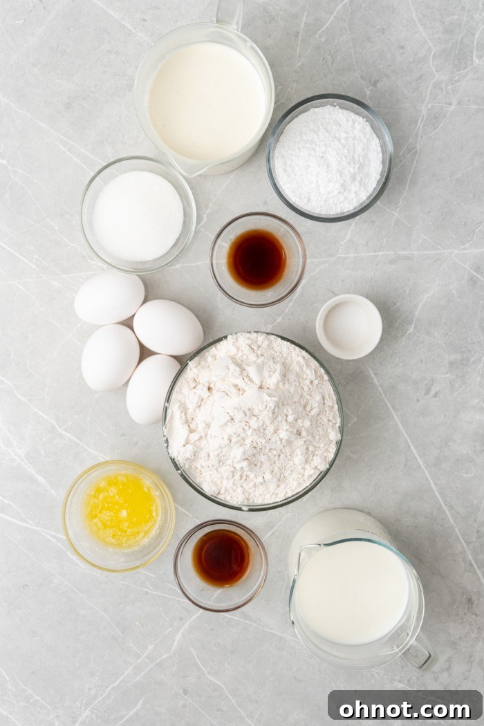 Various ingredients for crepe cake laid out on a table, including flour, eggs, milk, sugar, butter, and vanilla extract, ready for preparation.