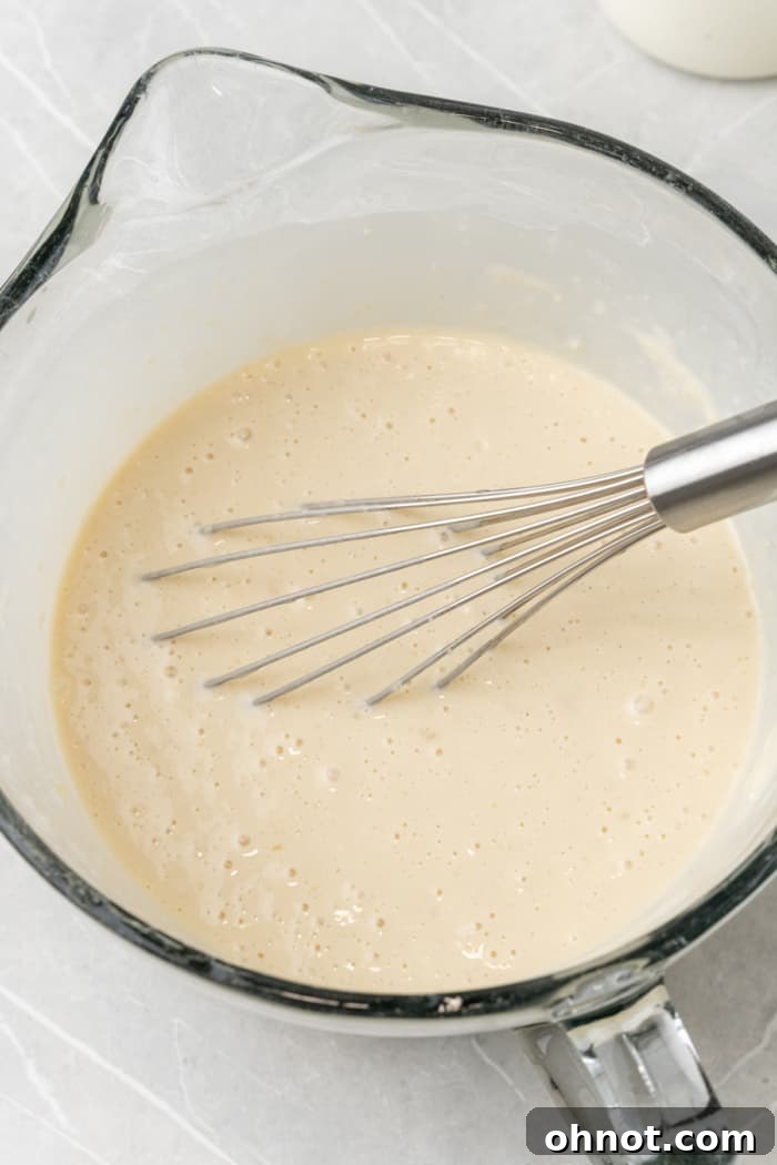 A bowl of smoothly whisked crepe batter, perfectly consistent and ready for cooking.