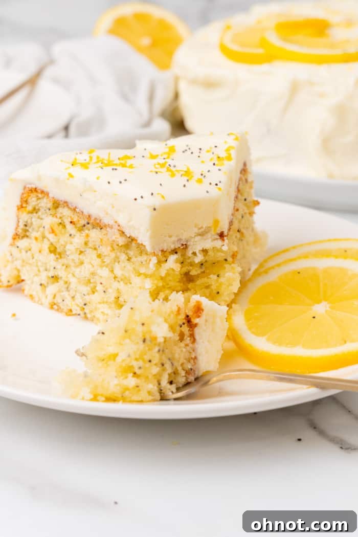 A beautifully frosted lemon poppy seed cake, ready to be sliced and served.