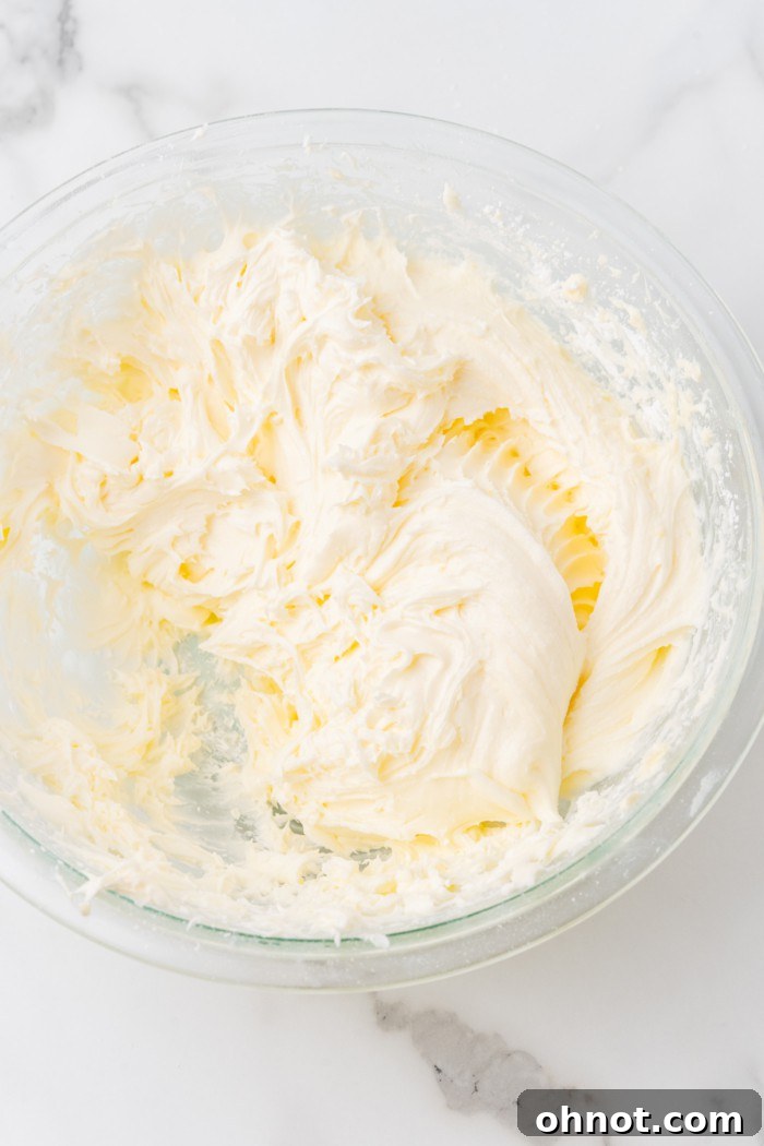 Light yellow, fluffy cream cheese frosting in a bowl.