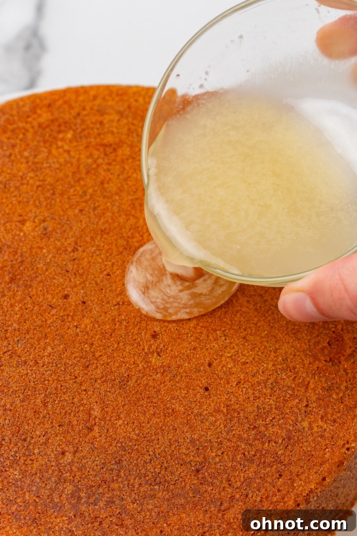 Lemon glaze being poured onto the cooled cake.