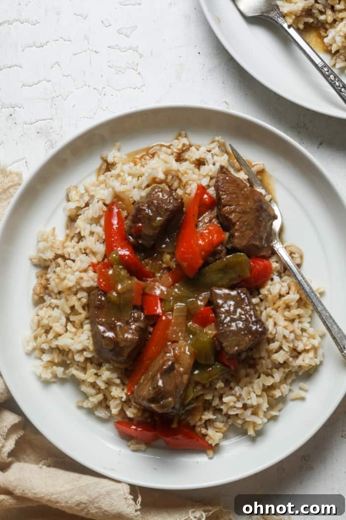 Beef tips and rice served on a plate, ready to eat.