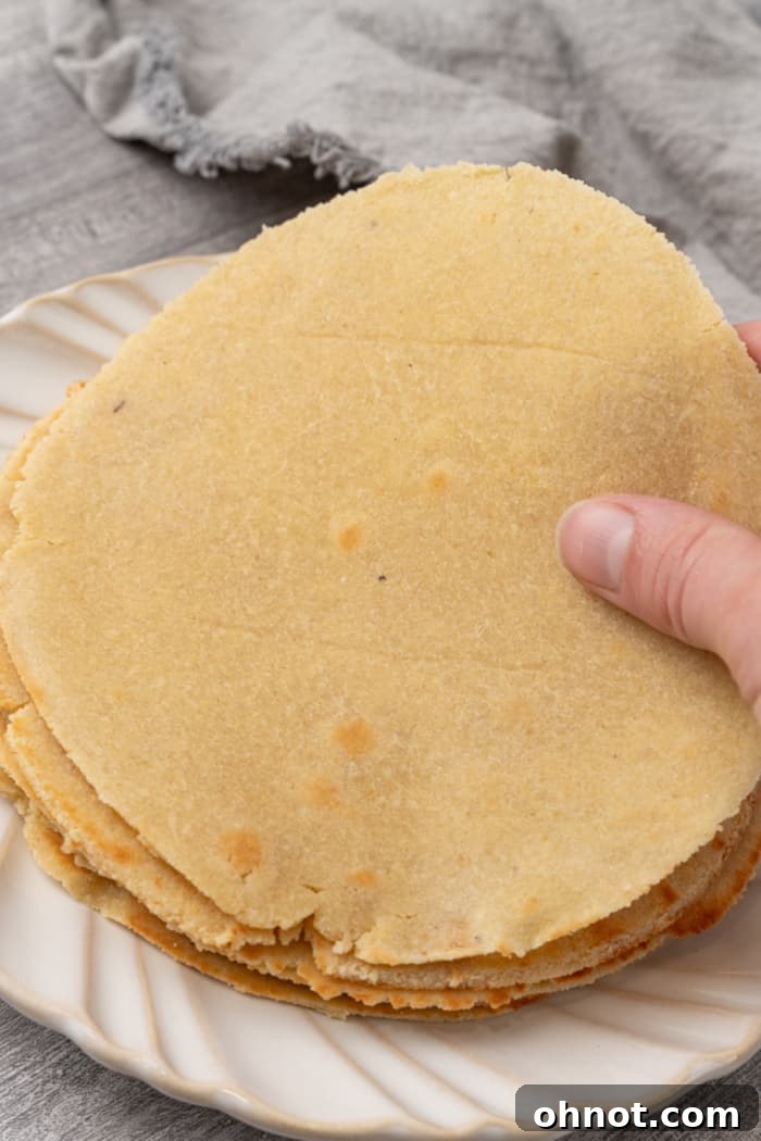 A plate of soft, pliable homemade almond flour tortillas, perfectly cooked and ready to be enjoyed.