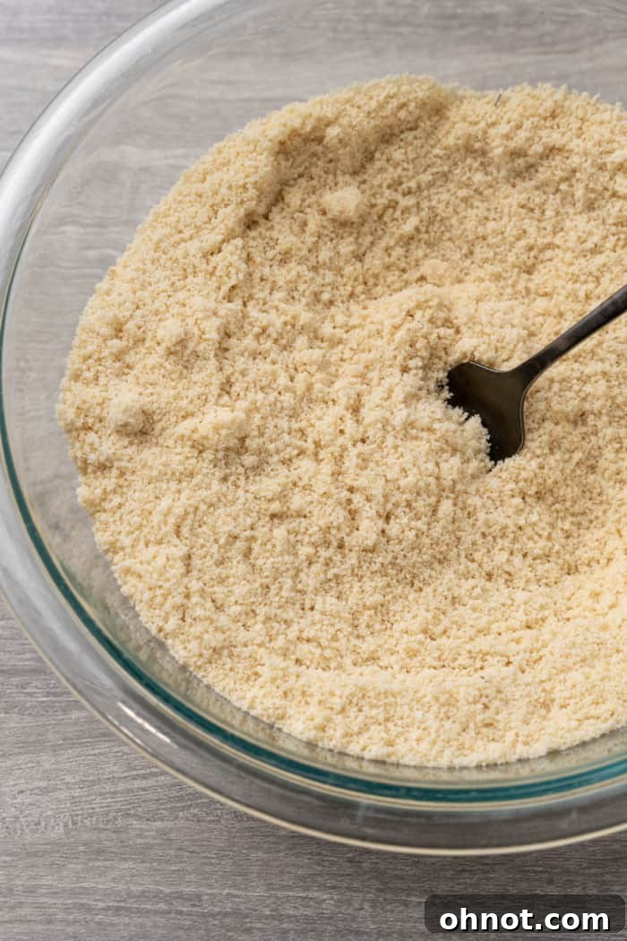 Close-up of sifted almond flour and coconut flour in a mixing bowl, showcasing their fine consistency.
