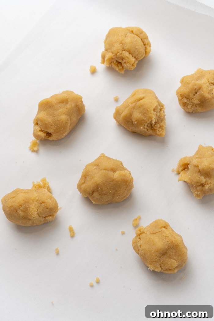 A close-up of smoothly rolled balls of almond flour dough, highlighting their uniform size.