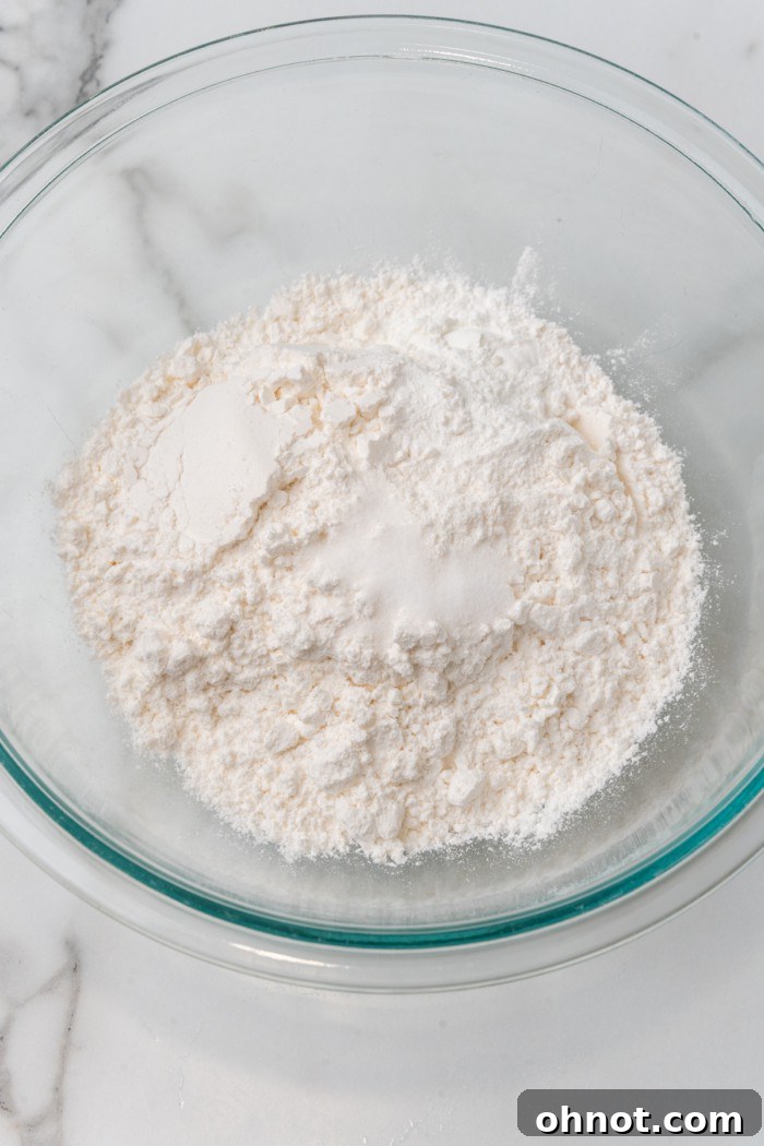 Gluten free flour and salt in a glass bowl, ready to be mixed.