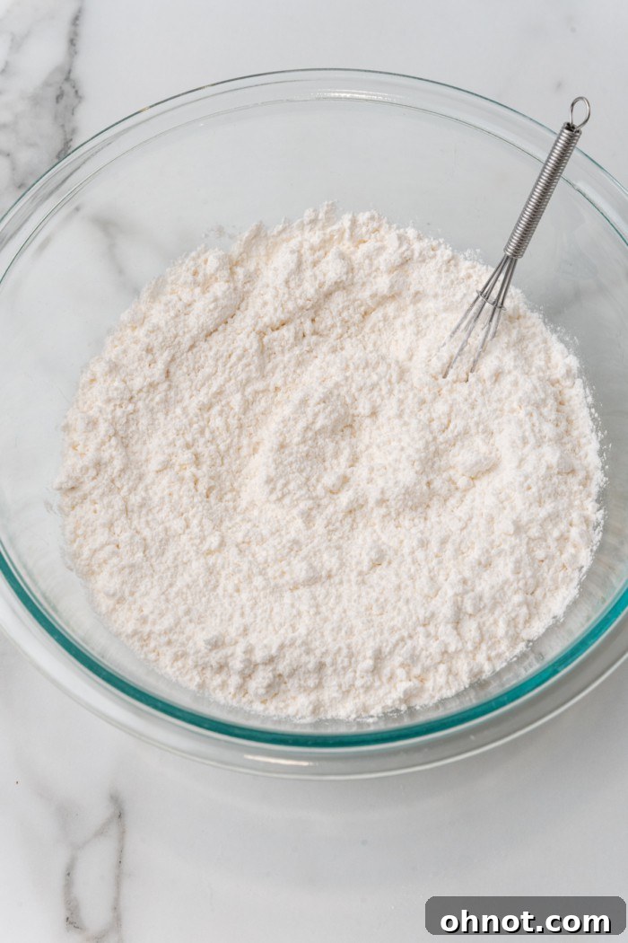 Mixed dry ingredients for gluten free biscuits in a glass bowl.