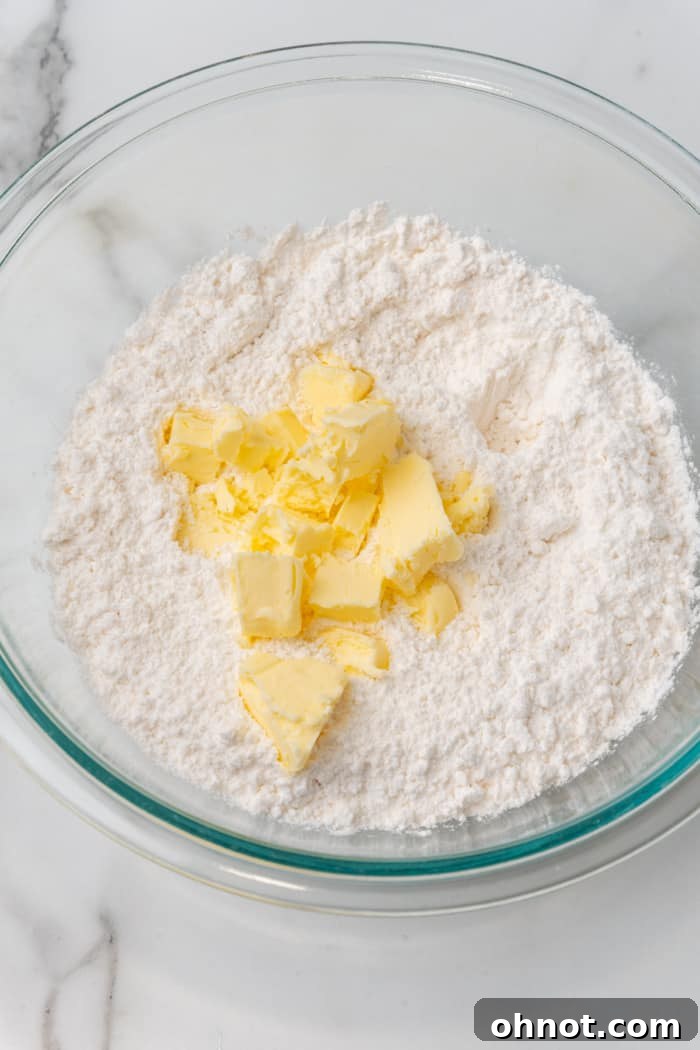 Cold cubed butter mixed with gluten free flour in a bowl.