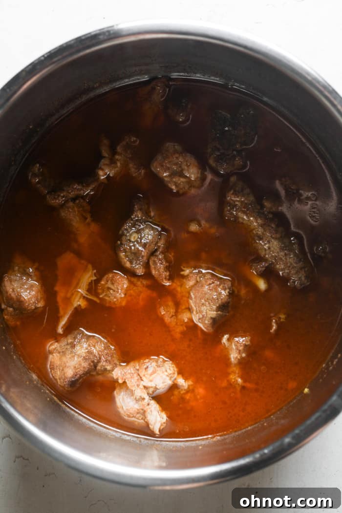 Instant Pot with the lid secured, pressure cooking pork carnitas.