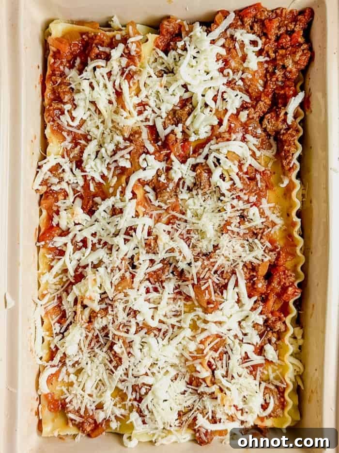 Assembled gluten-free lasagna in a baking dish before baking, showing multiple layers.