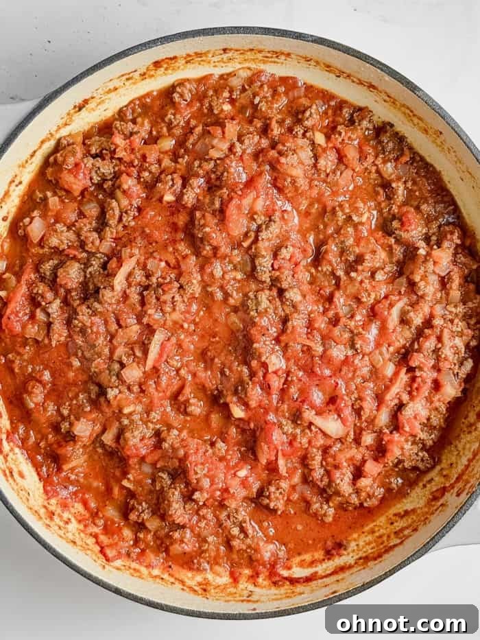 Thick, rich lasagna meat sauce simmering gently in a pan.