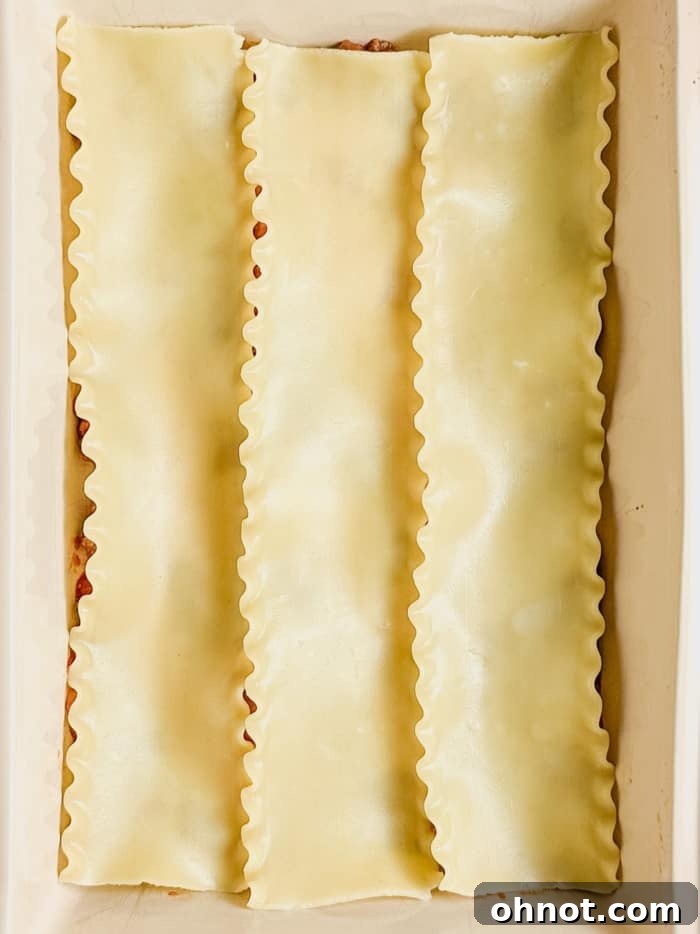 First layer of gluten-free lasagna noodles placed over the meat sauce in the baking pan.