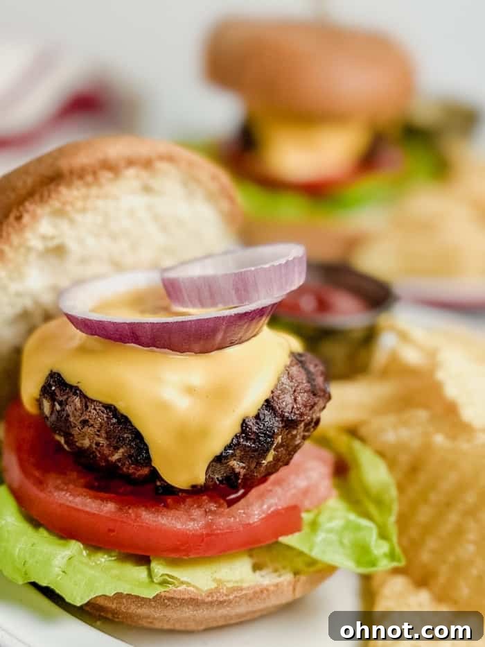 Close-up of a perfectly grilled gluten-free burger patty with fresh toppings on a bun, ready to be served.