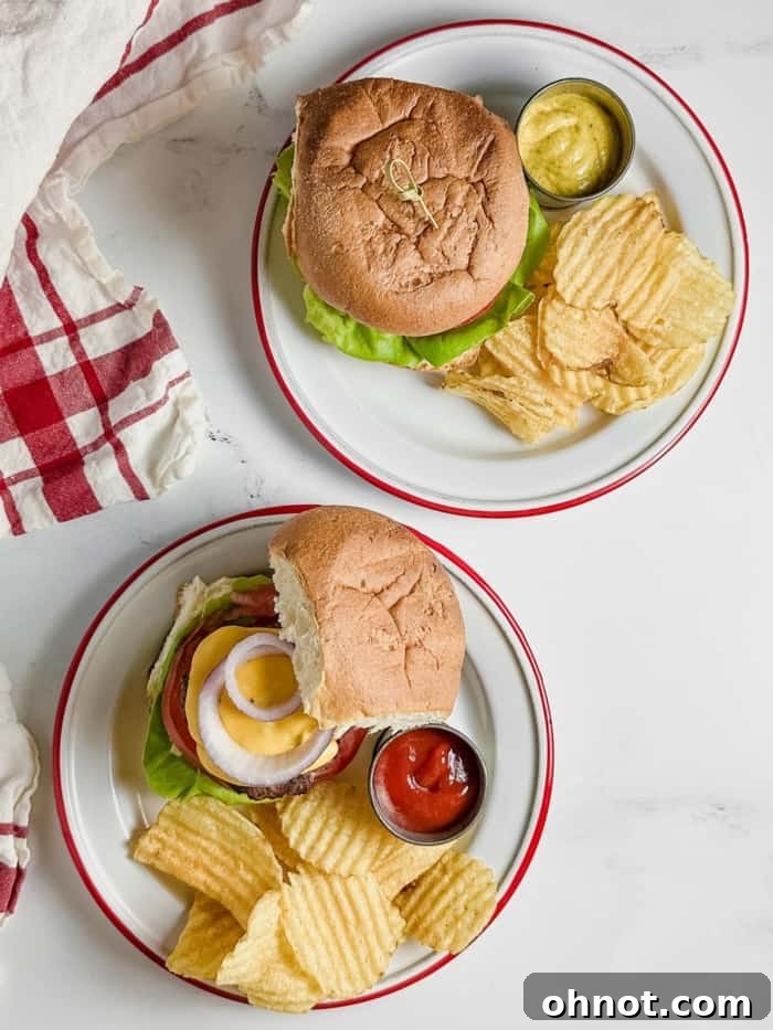 Two plates with fully assembled gluten-free cheeseburgers, served with a side of chips or fries.