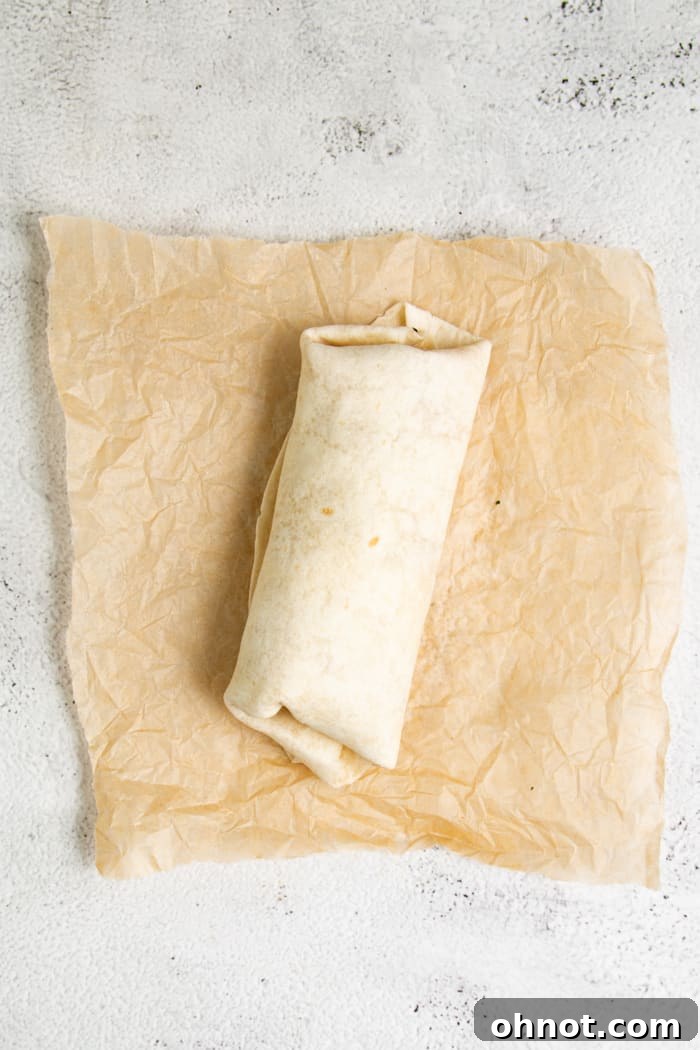 A perfectly rolled breakfast burrito, ready to be served or warmed.