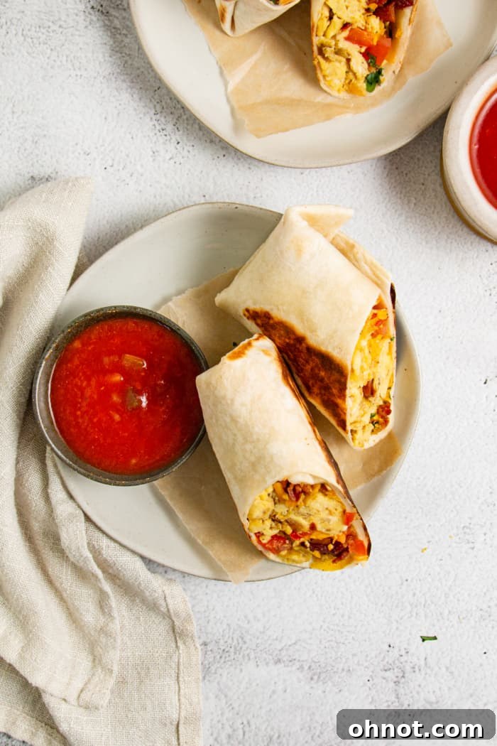 A healthy breakfast burrito on a plate, garnished with fresh herbs.