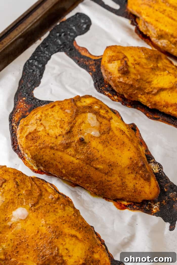 Chicken pieces, beautifully marinated and cooking on a pan or baking sheet.