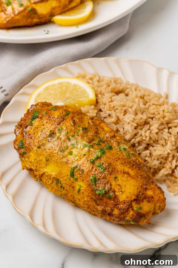 A plate of perfectly cooked Indian Tandoori chicken, garnished with fresh herbs.
