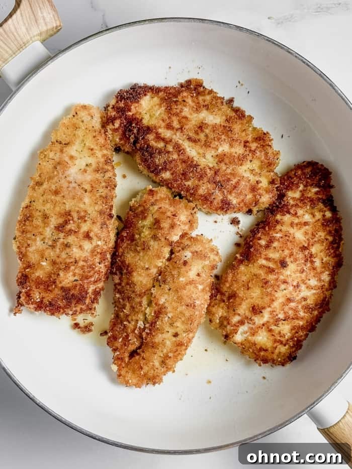 Crispy parmesan crusted chicken in skillet.