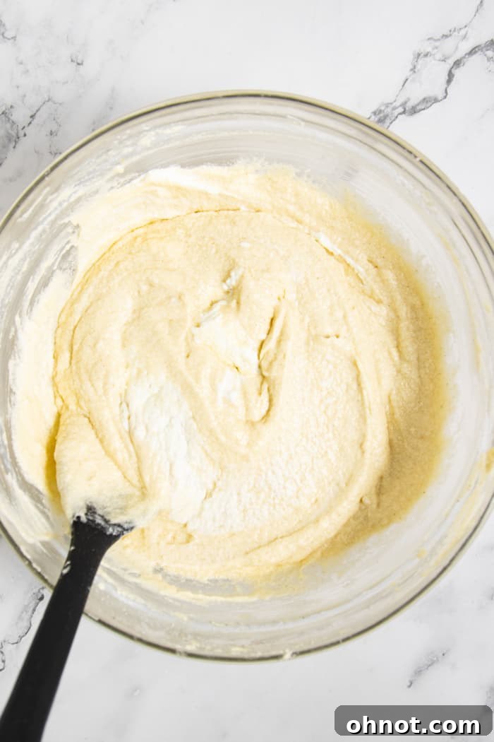 Smooth, thick white cupcake batter in a bowl.