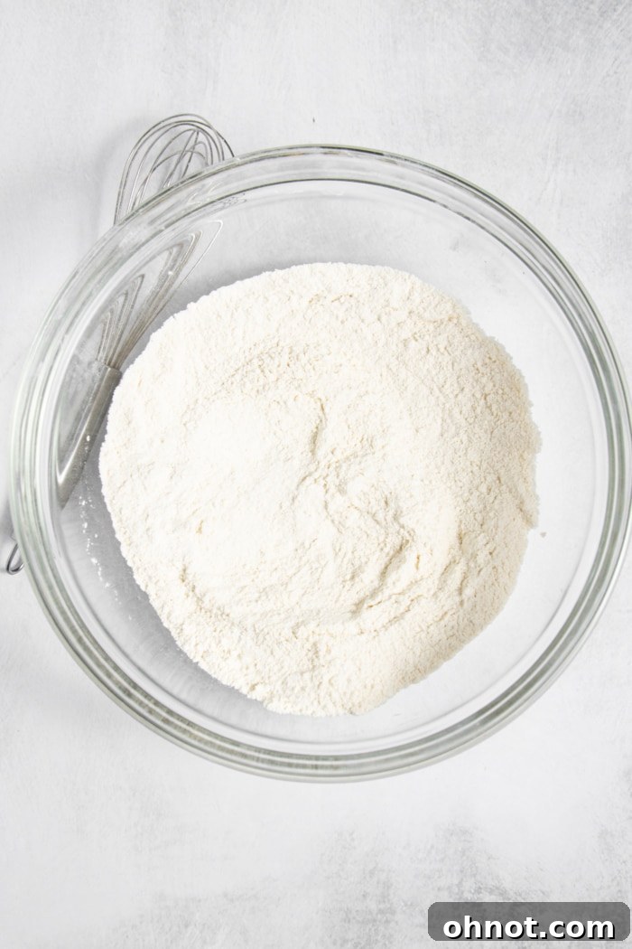 Gluten-free flour being whisked with dry ingredients in a bowl.