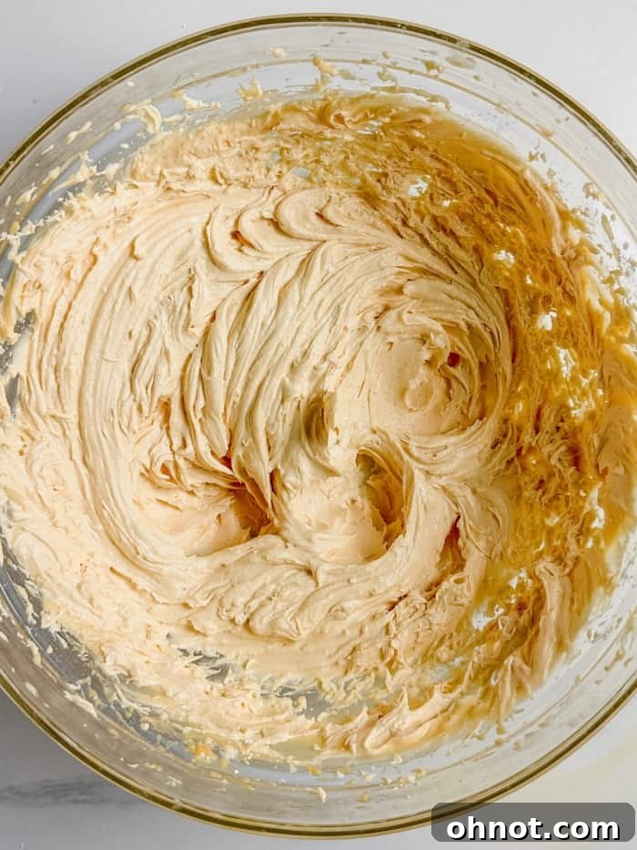 Creamy orange frosting in a mixing bowl.