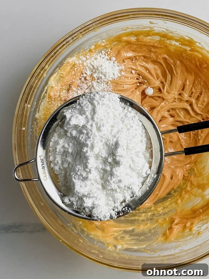 Powdered sugar being added to the frosting.