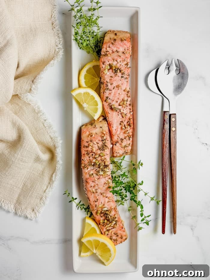 A beautiful platter of baked steelhead trout garnished with fresh lemon and thyme.