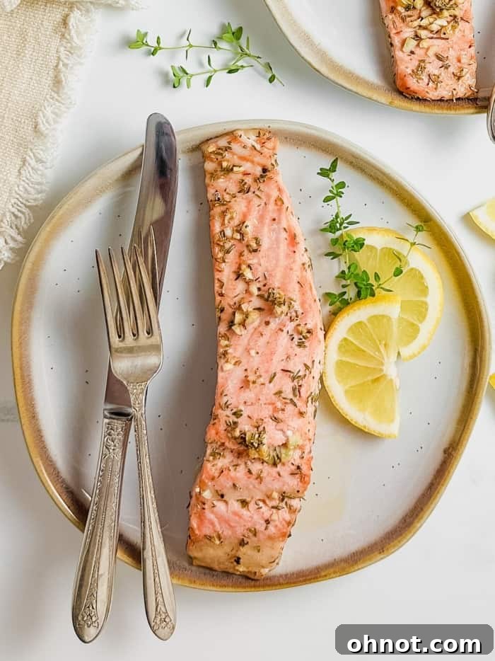 A close-up of a plate featuring baked steelhead trout, perfectly garnished.