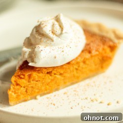 A slice of sweet potato pie with a golden crust and creamy filling.