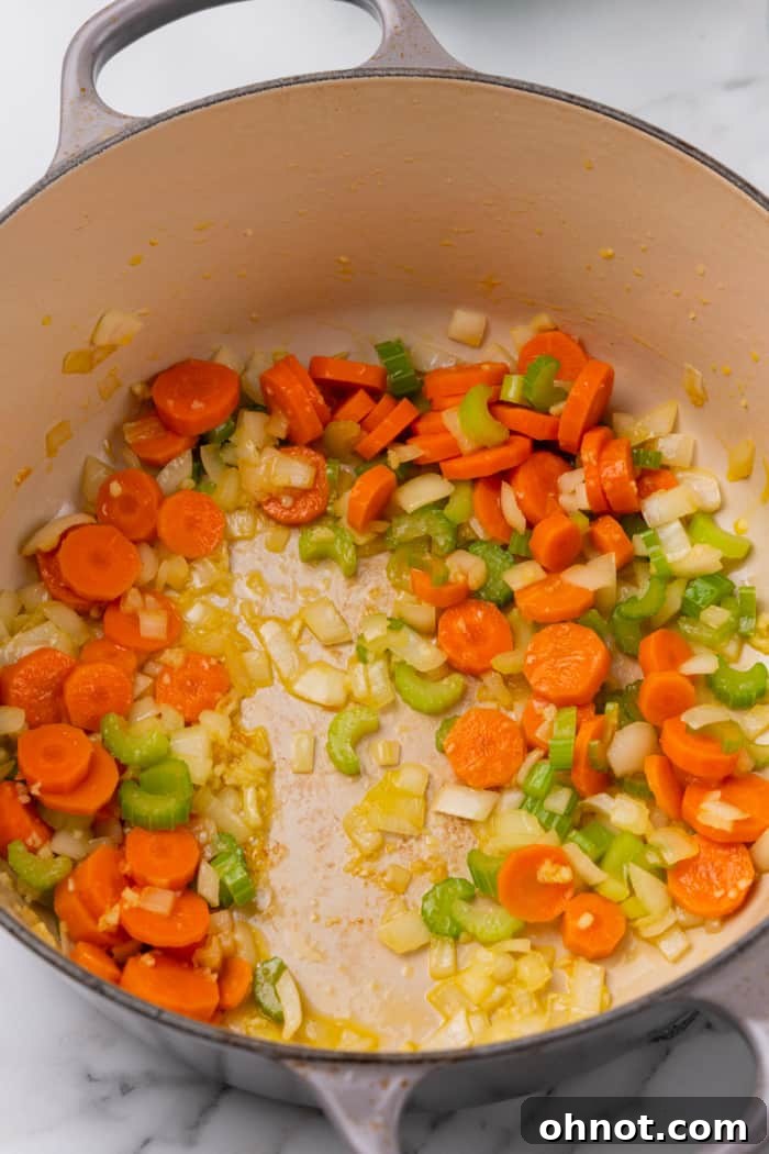 Perfectly softened and fragrant vegetables and garlic, gently cooked in a pot, forming the base of the soup.