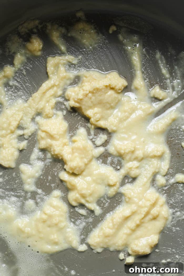 A smooth, golden butter and flour mixture (roux) in a skillet.
