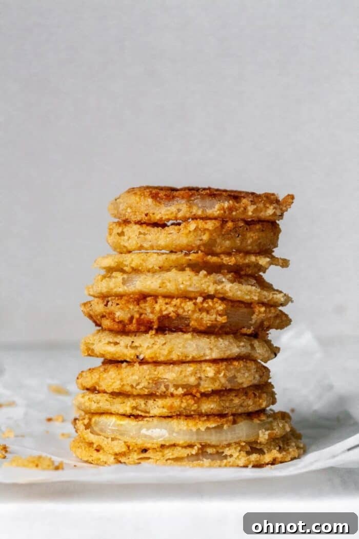 A stack of onion rings on white parchment paper.