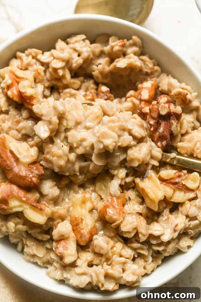 A vibrant bowl of vegan oats, generously topped with fresh berries, nuts, and a drizzle of syrup, ready to be enjoyed.