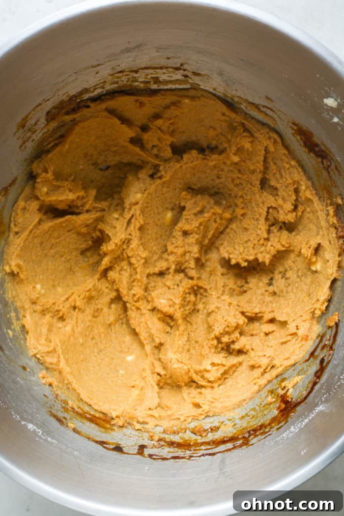 Creamed butter and molasses mixed with egg, showing a smooth, cohesive wet mixture.