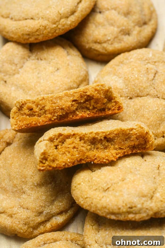 Gingersnap cookies with a beautiful cracked sugar coating, cooling on a rack.