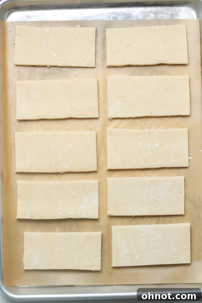Multiple rectangular dough pieces arranged on a baking sheet.