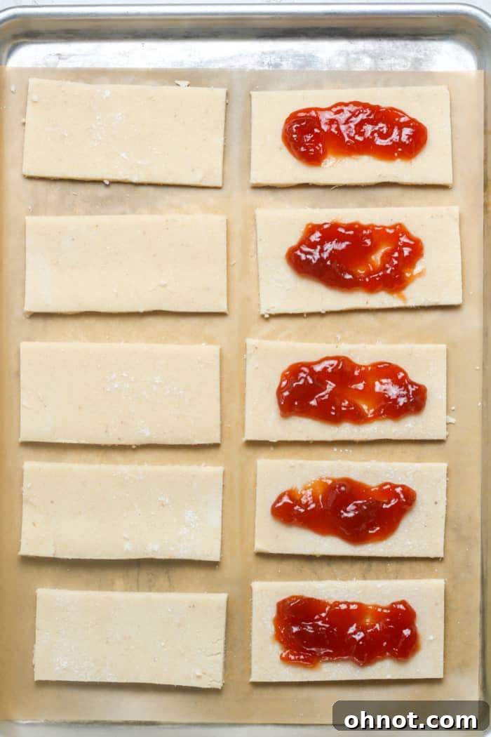 Dough rectangles with strawberry jam filling applied.