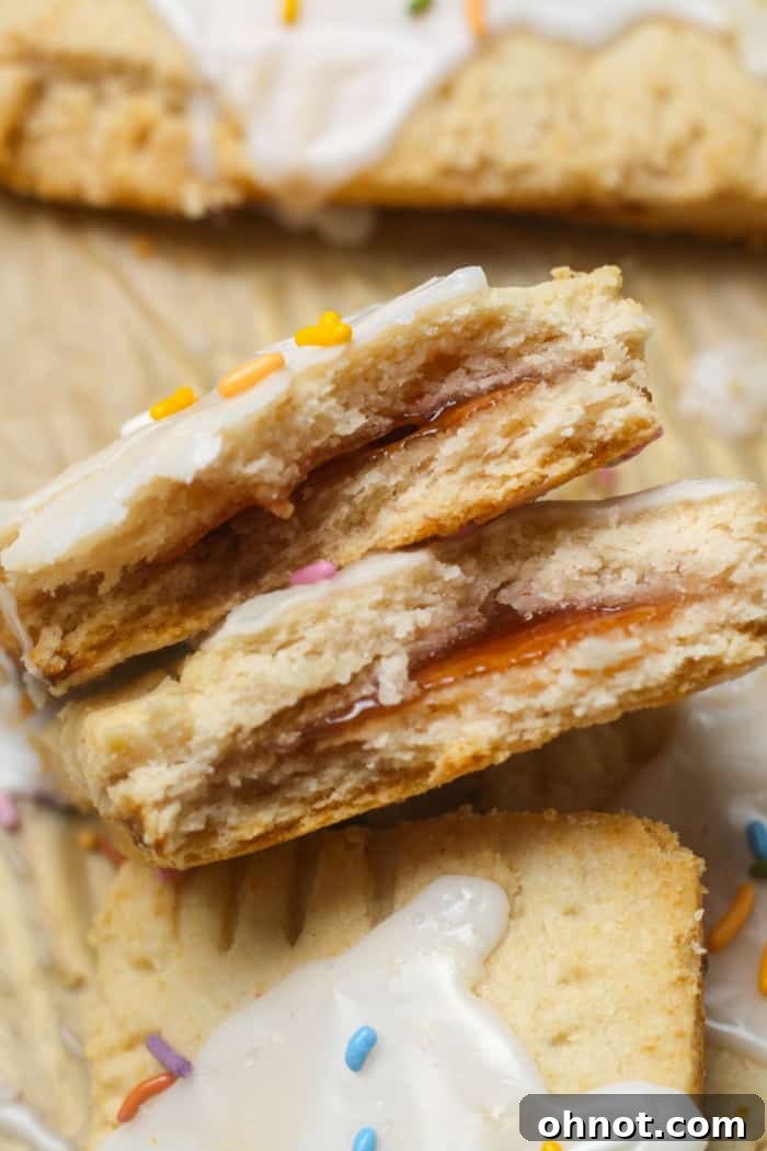Freshly baked strawberry pop tarts with white frosting and sprinkles.