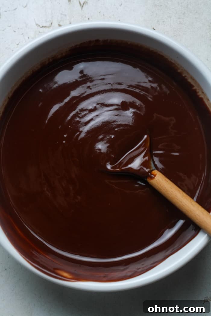 Creamy, glossy melted chocolate mixture in a glass bowl.