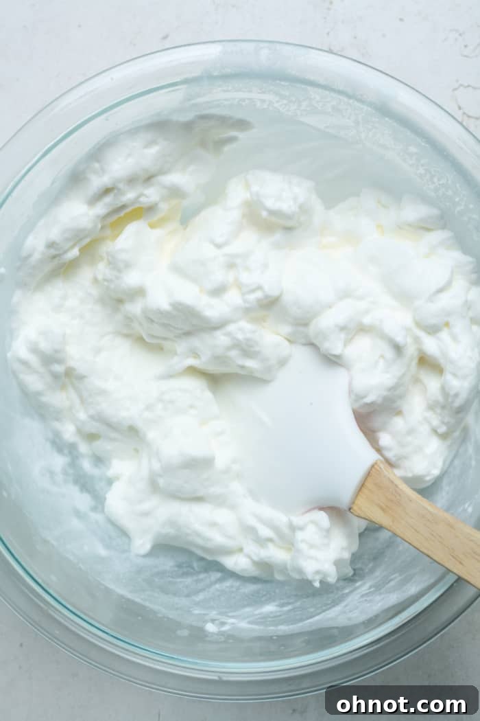 Bowl of perfectly whipped heavy cream with stiff peaks.