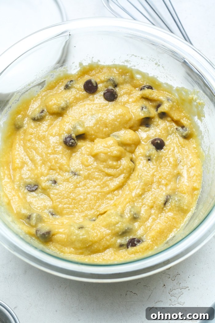 Close-up of muffin batter with dark chocolate chips folded in, showcasing the ready-to-bake mixture.