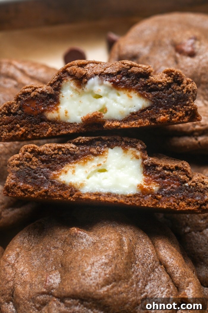 Close-up of a cut chocolate cheesecake cookie, revealing the creamy center.