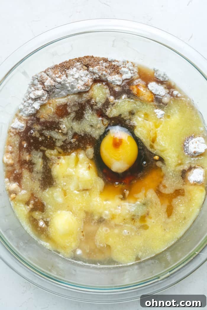 Close-up of egg, butter, and molasses being added to dry ingredients.