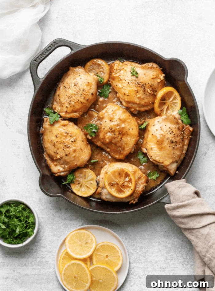 Perfectly seared Whole30 Lemon Chicken in a skillet, garnished with fresh parsley and lemon slices.