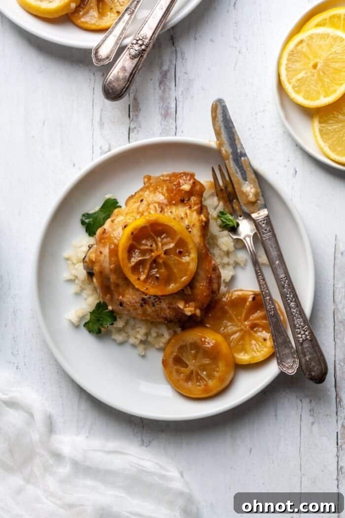 Plated Whole30 Lemon Chicken with cauliflower rice and fresh parsley garnish.