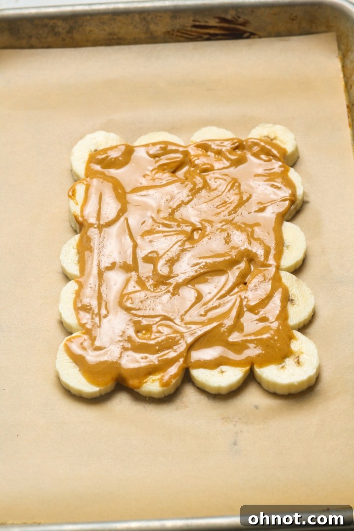 Banana slices covered with a smooth layer of peanut butter.