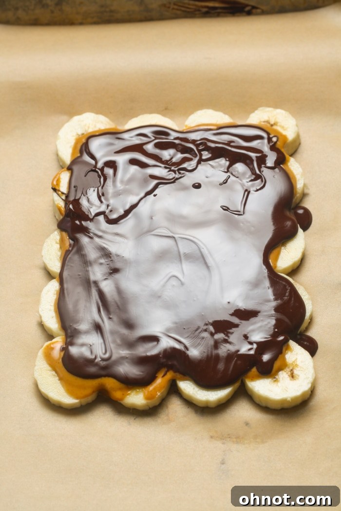 Melted chocolate being poured over the peanut butter and banana layers.
