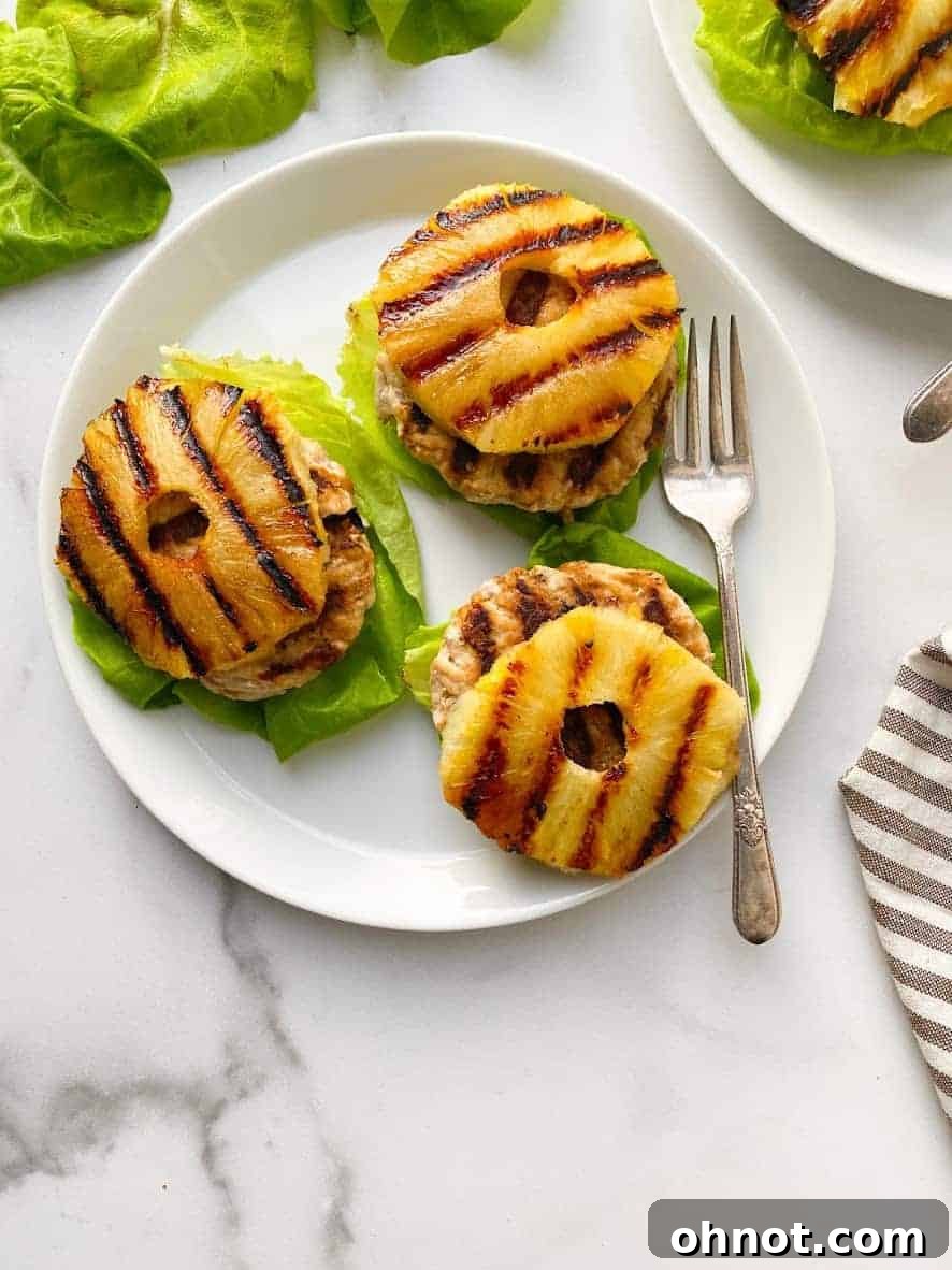 Grilled Teriyaki Chicken Burgers topped with pineapple and red onion, served on lettuce wraps.