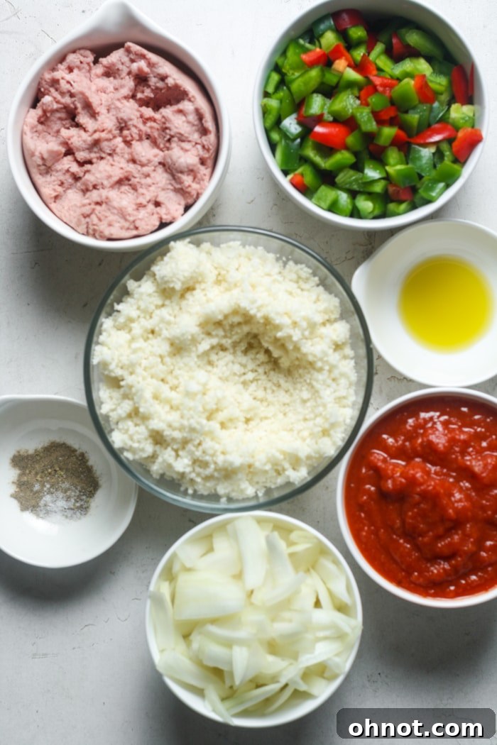 A selection of fresh ingredients laid out, including ground meat, colorful bell peppers, onions, a can of tomato sauce, and various herbs.